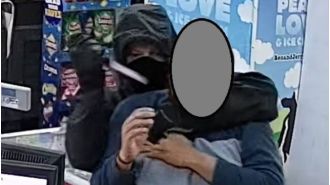 A worker at a supermarket was threatened with a knife by a robber who then stole money and escaped.