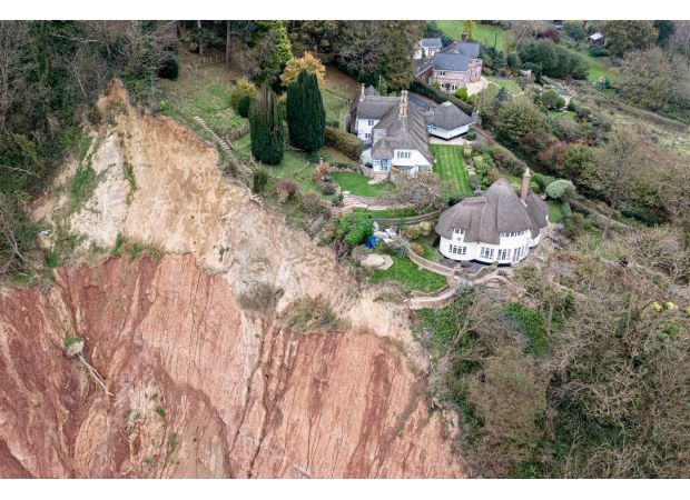 A cottage is in danger of falling off a 400ft cliff due to a huge landslide.