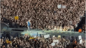 Lead singer of Coldplay surprises concertgoers with unexpected fall through stage opening.
