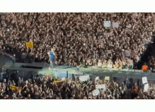 Lead singer of Coldplay surprises concertgoers with unexpected fall through stage opening.