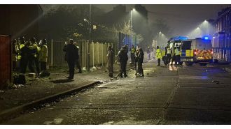 A group of young people throw fireworks at the police in Manchester.