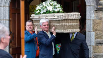 Phillip Schofield's wife supports him as he carries his mother's casket at her funeral.
