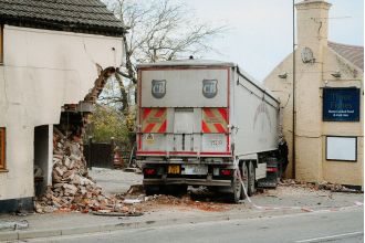 Truck veers off road, crashes into pub and house.