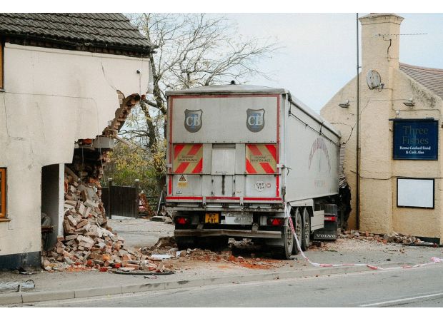 Truck veers off road, crashes into pub and house.