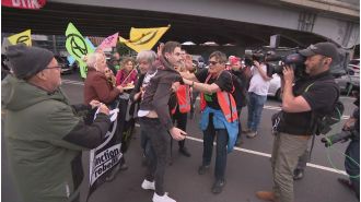Climate change protesters in Melbourne disrupt traffic by blocking a busy road.