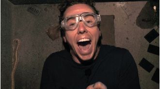 A celebrity on a reality show reveals a large snake by pulling down their shorts.