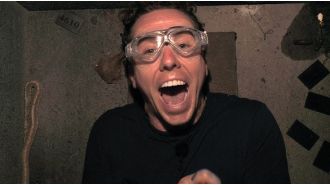 A celebrity on a reality show reveals a large snake by pulling down their shorts.