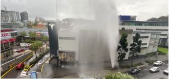 A broken water main in Brisbane causes a fountain of water and drenches the surrounding area.