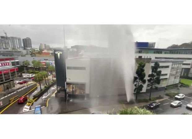 A broken water main in Brisbane causes a fountain of water and drenches the surrounding area.