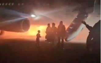 People escaped by sliding down emergency chutes as the plane caught fire during its landing.