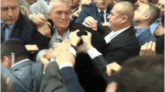 A physical altercation breaks out in the country's parliament, resulting in accusations and blame being placed on those involved.