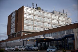 Vehicle slams into hospital, trapping people beneath.