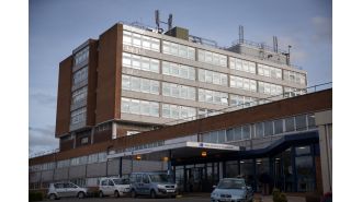 Vehicle slams into hospital, trapping people beneath.