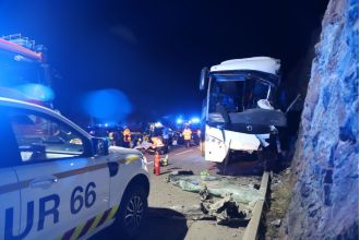 Multiple fatalities reported after tourist bus crashes into cliff wall.