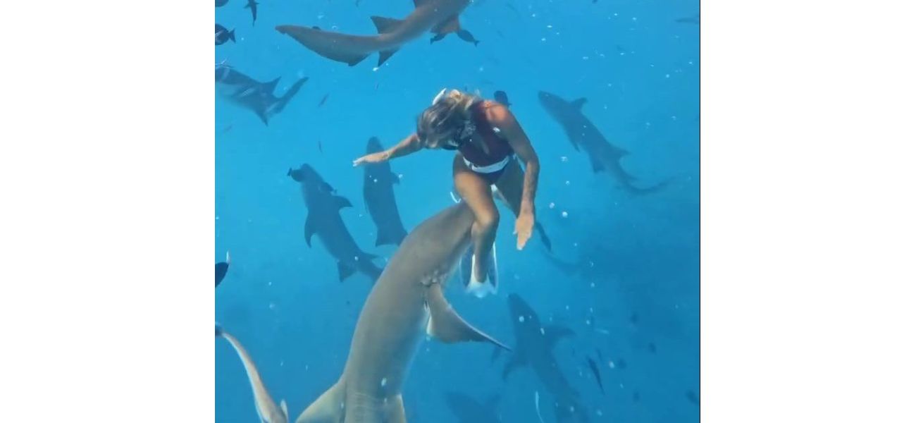 A woman is pulled into the sea by a shark biting her leg.