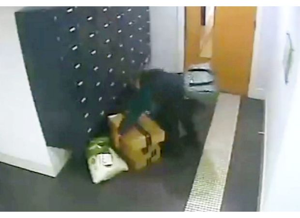 A woman boldly takes Amazon packages from apartment building.
