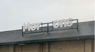 Morrisons is trying to fix their sign after a storm caused damage.