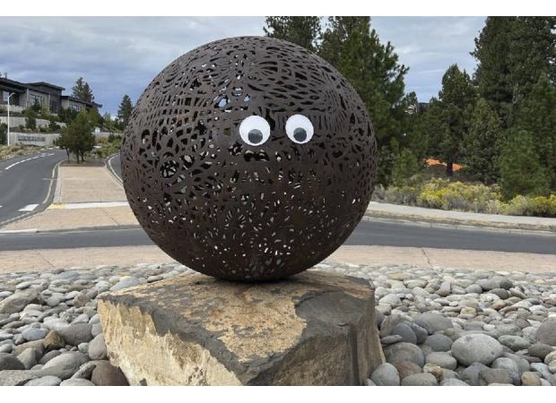 Unknown person adding fake cartoon eyes to artwork in public places.