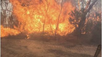 People leave their homes while a fire continues to rage in the north-west area of Melbourne.