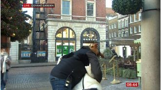 Carol Kirkwood calms audience after surprise on-air kiss from man.