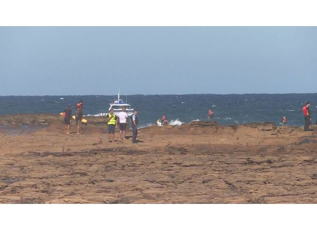 Authorities are frantically looking for a young boy who was swept away from the rocks at a beach on the NSW Central Coast.