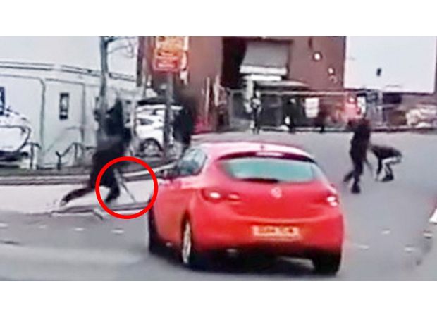 Students wielding machetes and large knives chase each other outside of a school.