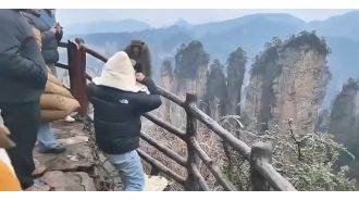 An aggressive tourist punches a mean monkey.