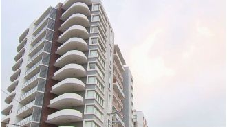 A man was taken into police custody following a woman's death from falling off a high-rise apartment.