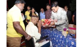 Minister of law gives out fruits and blankets at a shelter home.