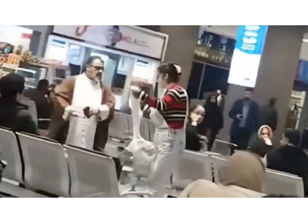 Woman bravely removes mullah's turban for hijab during airport confrontation.