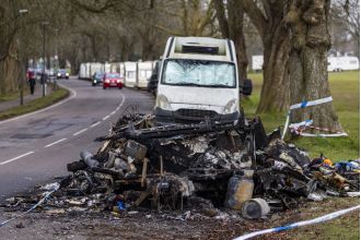 Residents of 'caravan city' defend themselves with weapons after an act of arson.
