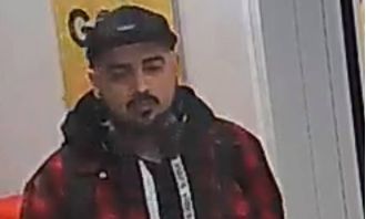 Police searching for suspect in cap and hoody after reported sexual assault at bus stop.