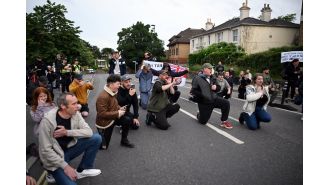 People kneel during vigil for Nowak, following recent riots in Southampton.