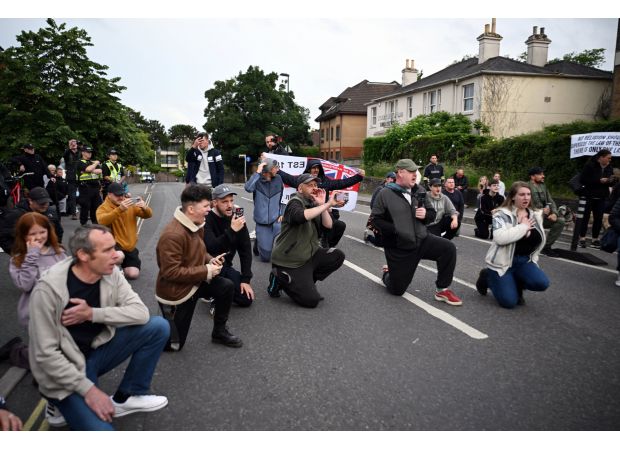 People kneel during vigil for Nowak, following recent riots in Southampton.