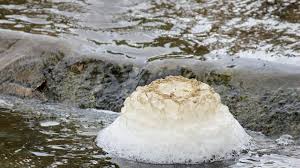 Foamy chemical water flows into the river